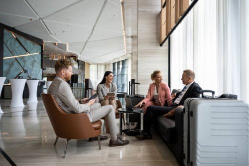 four colleagues sitting in a luxury hotel lobby and preparing for a business meeting. - travel stock pictures, royalty-free photos & images
