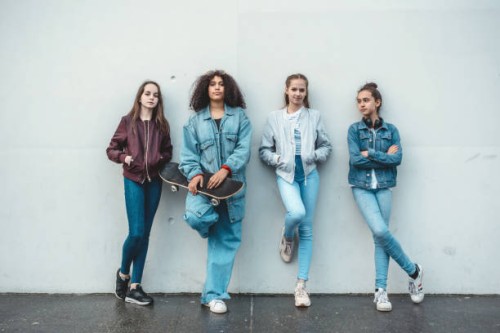 four teenage girls standing in front of concrete wall - fashion stock pictures, royalty-free photos & images