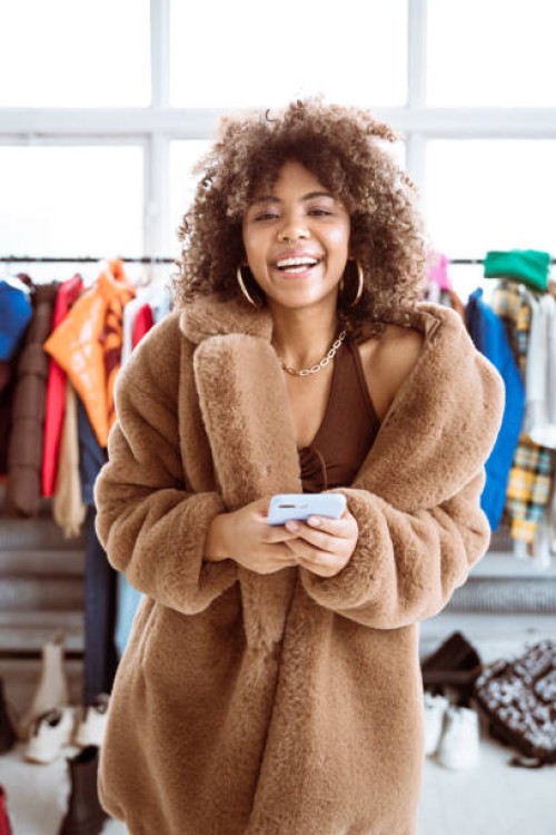 fröhliche influencerin im kunstpelzmantel - fashion stock-fotos und bilder