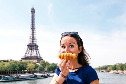 france, paris, staring woman with croissant in front of seine river and eiffel tower - food photos et images de collection