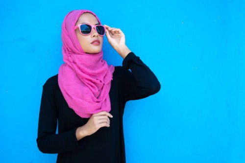 frau mit rosa hijab stehende arme gekreuzt - fashion stock-fotos und bilder