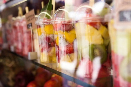 fresh colorful fruit salad in plastic packaging on street market - junk food stock pictures, royalty-free photos & images