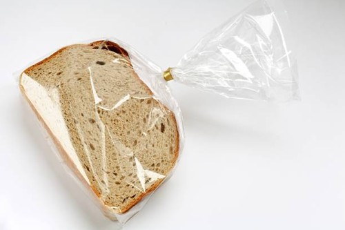 fresh sliced bread in transparent plastic folie on white - food stock pictures, royalty-free photos & images