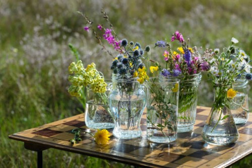 fresh wild flowers in upcycling jars on upcycling chess board table - home decoration stock pictures, royalty-free photos & images