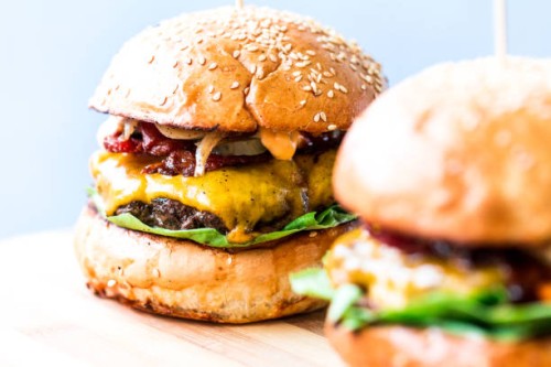 freshly flame grilled bacon cheese burgers in row - junk food stock pictures, royalty-free photos & images