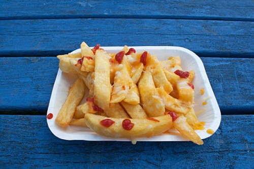 Fried chips or fries with tomato ketchup on.
