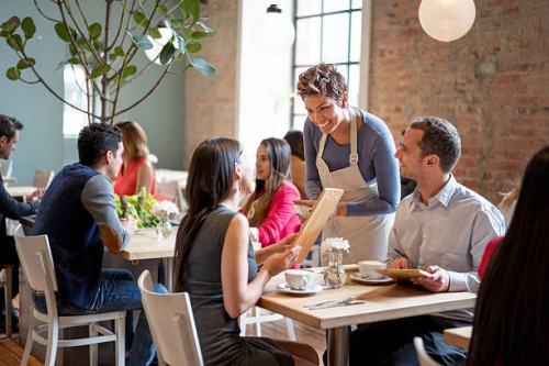 friendly waitress serving couple at a restaurant - food stock pictures, royalty-free photos & images