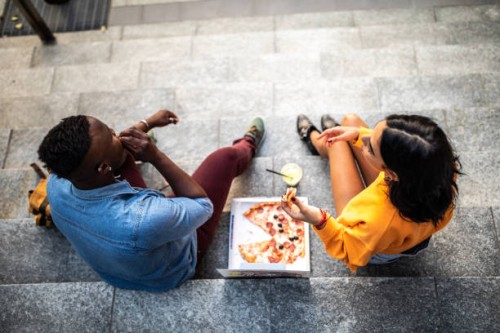 friends eating pizza outdoor - junk food stock pictures, royalty-free photos & images