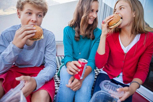 friends enjoying fast food together - junk food stock pictures, royalty-free photos & images