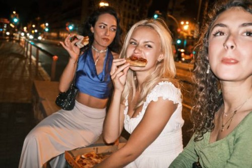 friends enjoying pizza on a city night - junk food stock pictures, royalty-free photos & images