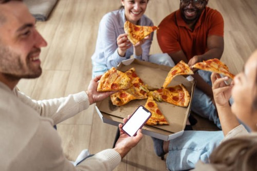 friends enjoying pizza together at home with smartphone interaction - phone with white screen - junk food stock pictures, royalty-free photos & images