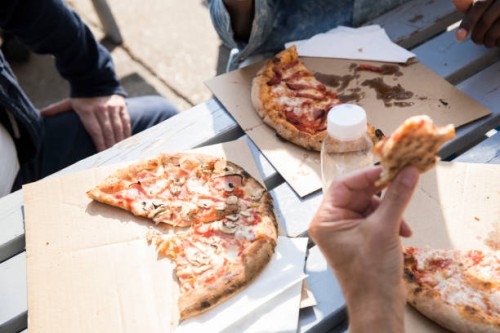 friends having pizza outdoors - junk food stock pictures, royalty-free photos & images