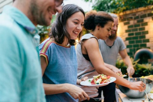 friends having summer barbecue together line up for food - food stock pictures, royalty-free photos & images