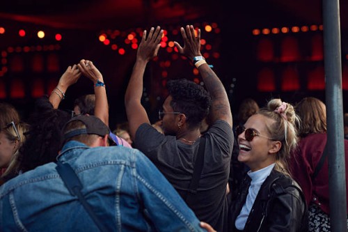 friends laughing at concert, arms in air - concert stock pictures, royalty-free photos & images