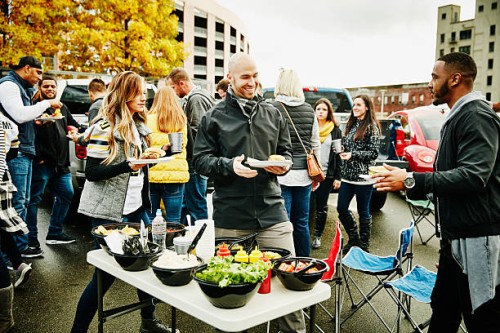 friends putting condiments on burgers during party - food stock pictures, royalty-free photos & images