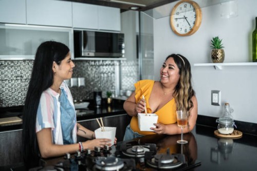 friends talking and eating asian food at home - junk food stock pictures, royalty-free photos & images