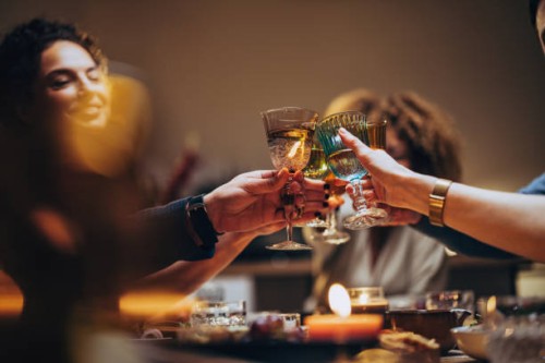 friends toasting with a glass of wine during a dinner celebration - food stockfoto's en -beelden