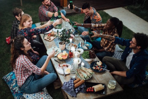 friends toasting with wine and beer at rustic dinner party - food stock pictures, royalty-free photos & images