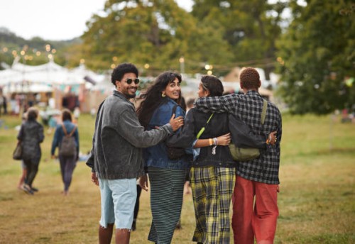 friends walking side by side with arms around at park - concert stock pictures, royalty-free photos & images