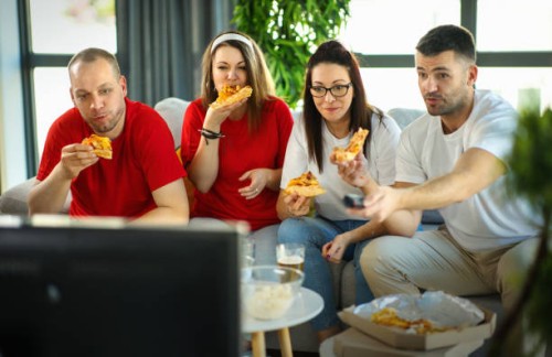 friends watching a game at home. - junk food stock pictures, royalty-free photos & images