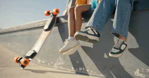 friends, women and shoes at a skate park outdoor in summer for fun, sports and skating. closeup of female people together with casual clothes and a skateboard for freedom, travel adventure and break - fashion stock pictures, 