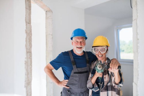 front view portrait of senior couple workers with drill in new home. - home decoration stock pictures, royalty-free photos & images