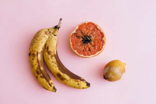 fruit with mold on a pink background - food stock pictures, royalty-free photos & images