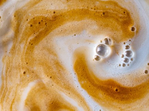 full frame of cup with milk and coffee in motion are mixed. - coffee stockfoto's en -beelden