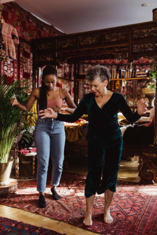 full length of grandmother and granddaughter dancing at home - fashion stock pictures, royalty-free photos & images
