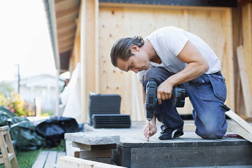 full length of man using cordless screwdriver nail into floorboard - home decoration stock pictures, royalty-free photos & images