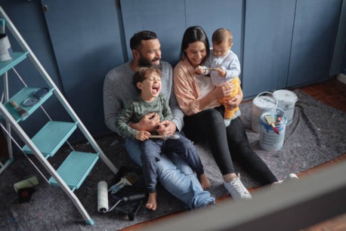 fun family renovating diy home improvements and painting new property together. above view of mother, father and children bonding. having fun, laughing, redecorating, designing purchased real estate - home decoration stock pi