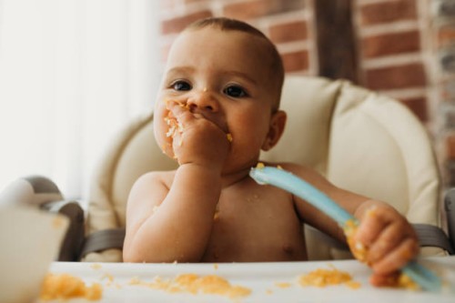 funny baby eating healthy food on kitchen - food stock pictures, royalty-free photos & images
