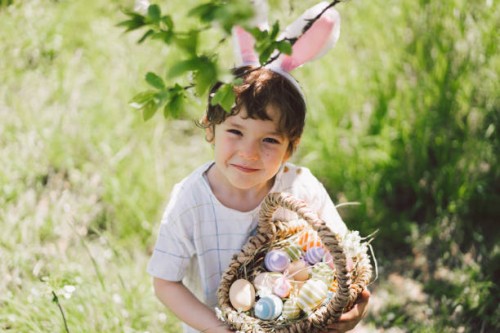 funny boy with eggs basket and bunny ears on easter egg hunt in sunny spring garden - garden decoration stock pictures, royalty-free photos & images