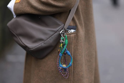 Gaius Okami seen wearing a brown long wool coat, grey hat, white blouse, sweater vest, beige brown Prada bag with details and black wide pants,...