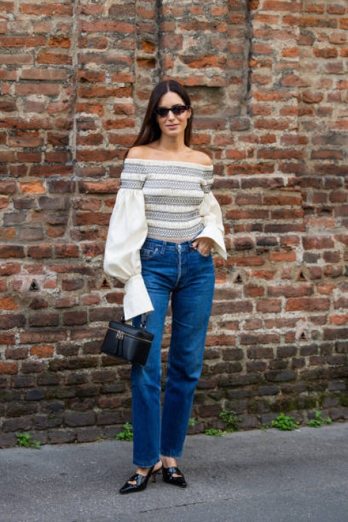 Gala Gonzalez wears off shoulder top with wide sleeves, denim jeans, black bag outside Max Mara during the Milan Fashion Week - Womenswear...