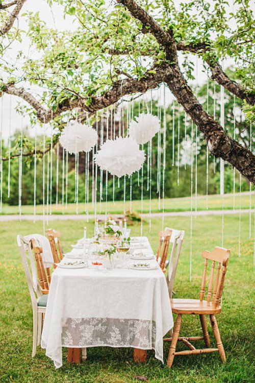 garden party arrangement with decorations hanging from tree. - garden decoration stock pictures, royalty-free photos & images