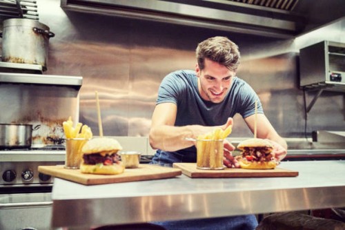 gelukkig chef-kok schikken hamburger en frietjes - junk food stockfoto's en -beelden