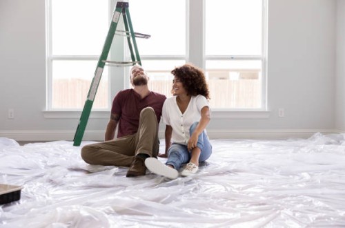 gelukkig paar ontspannen tijdens het schilderen van een kamer - home decoration stockfoto's en -beelden