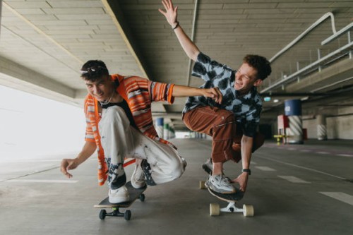 generation z friends riding skateboards in parking garage. - fashion stock pictures, royalty-free photos & images