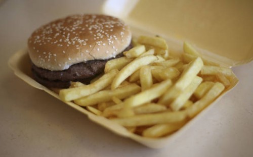 Generic stock photo of a half-pounder burger and chips in a takeaway carton.