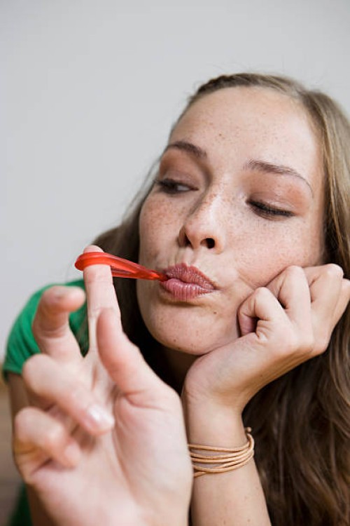 germany, berlin, young woman eating wine gum, portrait, close-up - junk food stock-fotos und bilder