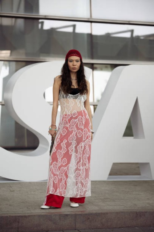 Geust wears red wide Adidas pants, black bikini top, white lace dress, red beanie and Louise Vuitton bag on day 2 of Visa Fashion Week Almaty 2024 on...