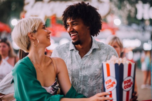 girl and boy eating popcorns - concert stock pictures, royalty-free photos & images