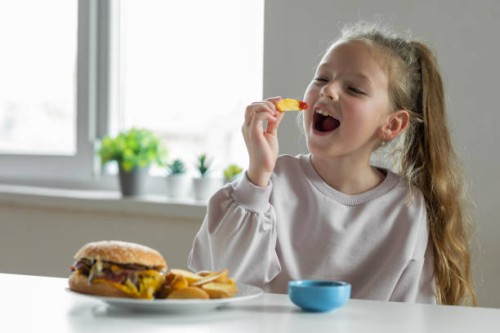 girl eating french fries with tomato ketchup - junk food stock pictures, royalty-free photos & images