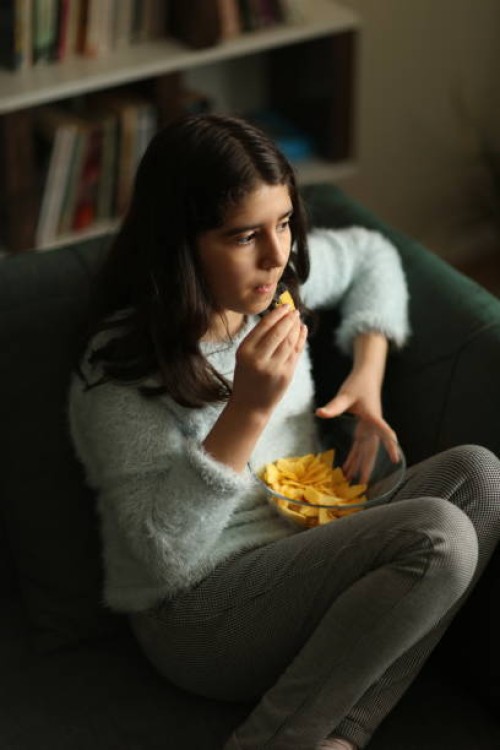 girl eating potato crisps - junk food stock pictures, royalty-free photos & images