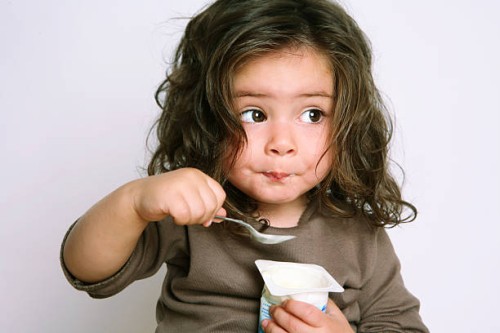 girl eating yogurt - food stock pictures, royalty-free photos & images