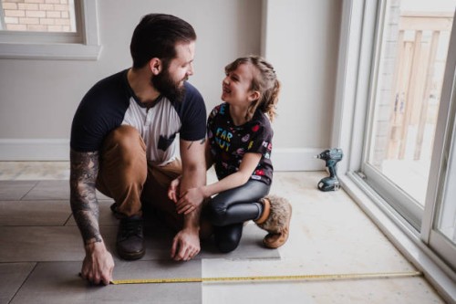 girl helping father install floor tiles - home decoration fotografías e imágenes de stock