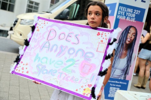 Girl holds up a sign asking if anyone has a spare ticket, as Taylor Swift fans, also known as "Swifties", arrive at Wembley Stadium ahead of her...