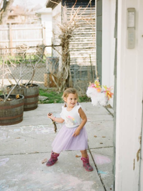 girl in unicorn dress swinging at a piñata - garden decoration stock pictures, royalty-free photos & images