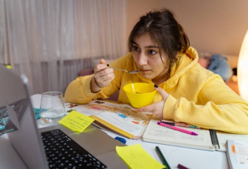 girl is working on homework for school. young female reading research articles about her hobby. education concept - junk food stock pictures, royalty-free photos & images